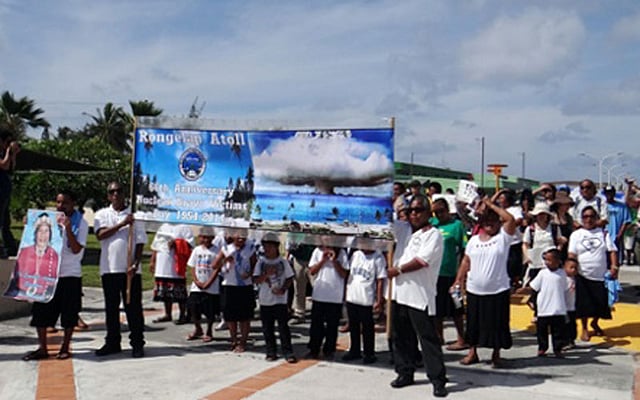 পরমাণু পরীক্ষার ৬০তম বার্ষিকীতে রঙেলাপ দ্বীপপুঞ্জের বাস্তুচ্যুত বাসিন্দাদের মিছিল। ছবি: এএফপি