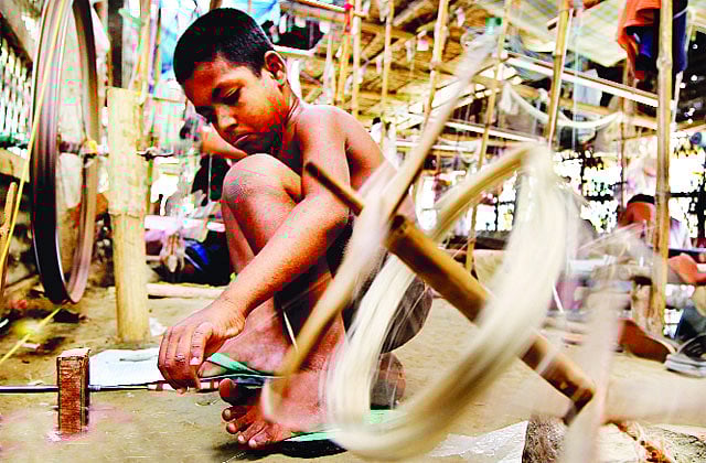 নারায়ণগঞ্জের রূপগঞ্জে তাঁতের কাপড় তৈরির কারখানায় কর্মরত এক শিশুশ্রমিক । ছবি: হাসান রাজা