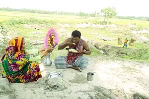 ছেলে খাচ্ছেন, পরম মমতায় বাতাস করছেন মা। ছবিটি রংপুর উত্তম এলাকা থেকে গতকাল তোলা । প্রথম আলো