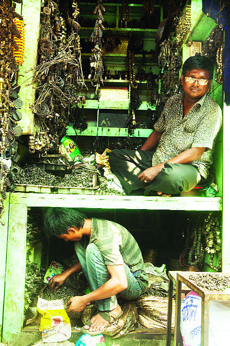 বরবটিসদৃশ যন্ত্রাংশ সাজিয়ে বসে আছেন মো. মতিন, নিচে কর্মচারী