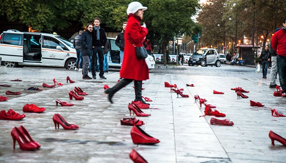 নারীর প্রতি সহিংসতার বিরুদ্ধে সচেতনতা গড়তে ইতালির পালের্মো শহরের রাজপথে এভাবেই রেখে দেওয়া হয়েছিল শত জোড়া লাল জুতা। পথচারীরা পড়ে থাকা জুতার মাঝ দিয়ে হেঁটে যাবেন আর বিষয়টি নিয়ে ভাববেন। এটাই শিল্পীর চাওয়া। ছবি: দ্য গার্ডিয়ান