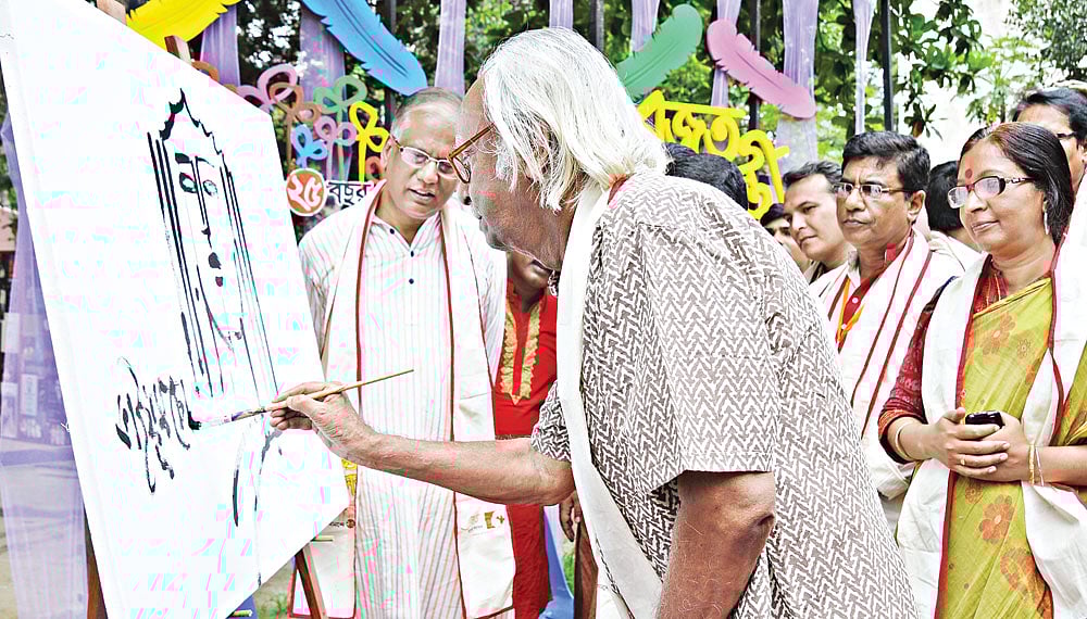 কেন্দ্রীয় গণগ্রন্থাগার চত্বরে‍ গতকাল ছবি এঁকে ‘স্রোত আবৃত্তি সংসদ’–এর রজতজয়ন্তী অনুষ্ঠানের উদ্বোধন করেন শিল্পী কাইয়ুম চৌধুরী l ছবি: প্রথম আলো