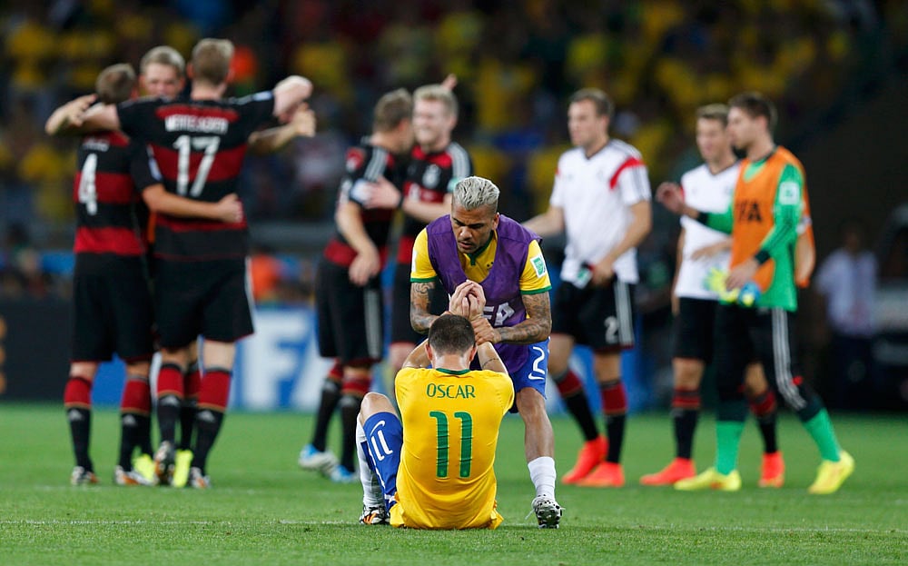 কান্নায় ভেঙ্গে পড়েছেন অস্কার। সামনেই উল্লাসে মেতে উঠেছেন জার্মানির খেলোয়াড়েরা। ছবি: রয়টার্স