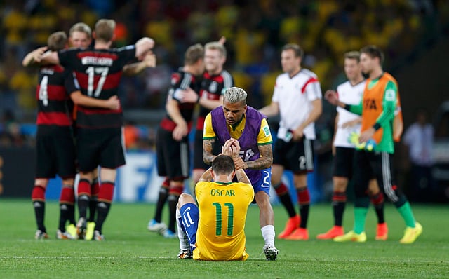 কান্নায় ভেঙ্গে পড়েছেন অস্কার। সামনেই উল্লাসে মেতে উঠেছেন জার্মানির খেলোয়াড়েরা। ছবি: রয়টার্স