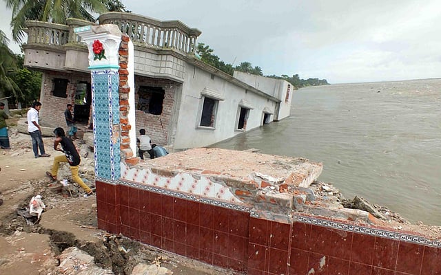 পদ্মার গর্ভে যাচ্ছে অনেক সাধে গড়া ভবন। ছবিটি সোমবার ঢাকার দোহার উপজেলার নারিশা পশ্চিম চর থেকে তোলা। ১৫ দিনের ভাঙনে সেখানে প্রায় দুই কিলোমিটার জনবসতি নদীগর্ভে বিলীন হয়েছে। এতে নিঃস্ব হয়েছে প্রায় ১ হাজার ৫০০ পরিবার। ছবি: আজহারুল হক, নবাবগঞ্জ (ঢাকা) প্রতিনিধি