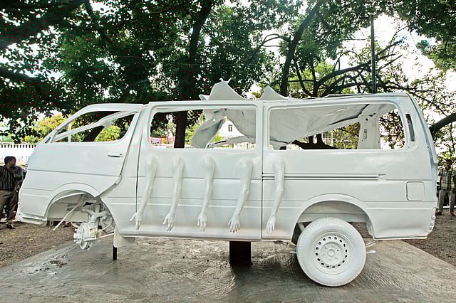 বাসের সঙ্গে মুখোমুখি সংঘর্ষে দুমড়ে গেছে মাইক্রোবাসটির ওপাশ। এপাশ অনেকটাই অক্ষত। তাতে প্রতীকী পাঁচটি হাত দিয়ে শিল্পী ঢালী আল মামুন নিহত পাঁচজনকে স্মরণ করলেন l ছবি: প্রথম আলো