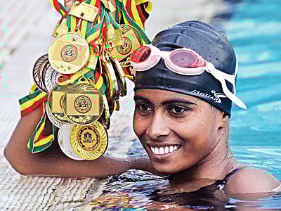 পদকগুলো যেন পদ্ম ফুল হয়ে ফুটে আছে হাতে। সোনাজয়ী বগুড়ার মরিয়ম, তাঁর সংগ্রহে ১০টি সোনা। কাল মিরপুর সুইমিং পুলে l প্রথম আলো