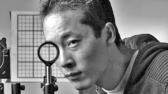 জোসেফ চোয়া দেখাচ্ছেন চারটি লেন্সের সমন্বয়ে তৈরি যন্ত্রটি কীভাবে পেছনের দৃশ্যকে সামনে নিয়ে এসে তাকে আড়াল করে দিতে পারে l ছবি: ইউনিভার্সিটি অব রচেস্টার