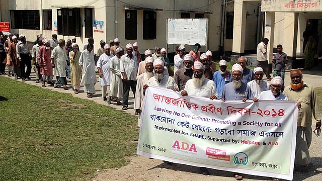 ‘থাকবো না কেউ পেছনে, গড়বো সমাজ একসঙ্গে’ এই শ্লোগানে বুধবার আন্তর্জাতিক প্রবীন দিবস উপলক্ষে রংপুরের গঙ্গাচড়া উপজেলায় কয়েকটি বেসরকারি সংগঠনের আয়োজনে প্রবীনরা একটি র্যালী বের করে। ছবিটি উপজেলা স্বাস্থ্য কমপ্লেক্সের সামনের সড়কে তোলা। ছবি: মঈনুল ইসলাম, রংপুর