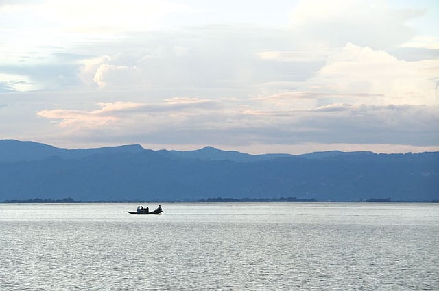 উল্টোদিকে ডুবছে সূর্য। নীল পাহাড়ে তার আভা। টাঙ্গুয়ার হাওর, তাহিরপুর