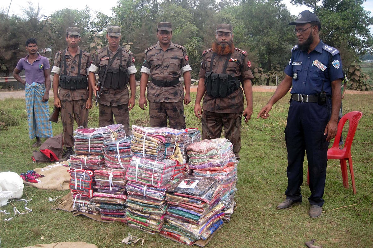 সীতাকুণ্ডের ছলিমপুরে আটক করা ভারতীয় শাড়িসহ বিজিবির সদস্যরা । ছবি: কৃষ্ণচন্দ্র দাস