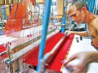 মিরপুর ১১ নম্বরের একটি কারখানায় গতকাল বেনারসি শাড়ি তৈরিতে ব্যস্ত এক কারিগর। এই কারখানায় অনেক তাঁত থাকলেও বন্ধ হয়ে গেছে বেশির ভাগ l ছবি: প্রথম আলো