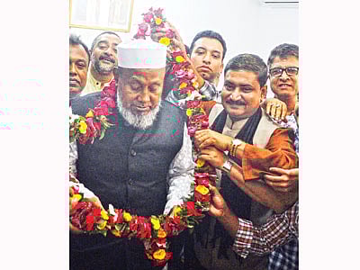 চট্টগ্রামের সাবেক মেয়র মহিউদ্দিন চৌধুরীকে মালা পরিয়ে দিচ্ছেন মামুনুর রশীদ (সাদা কটি, কালো মাফলার পরা)। ১ ডিসেম্বর ছবিটি তোলা l সংগৃহীত