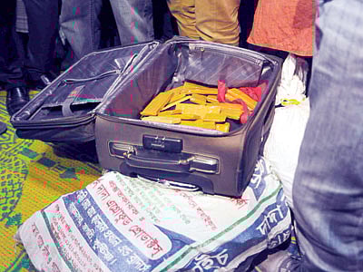 রাজধানীর পুরানা পল্টনের একটি বাসা থেকে গতকাল উদ্ধার করা সোনার বার এবং দেশি-বিদেশি মুদ্রা (বস্তার মধ্যে) l ছবি: প্রথম আলো