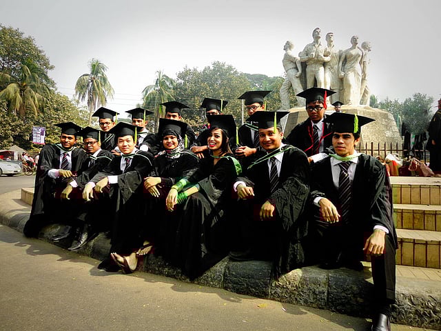 ঢাকা বিশ্ববিদ্যালয়ের ৪৯তম সমাবর্তনে রাজু ভাস্কর্যের সামনে সমাবর্তন পোশাকে কয়েকজন শিক্ষার্থী। ছবি: সংগৃহীত