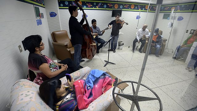 ভেনেজুয়েলার কারাকাসে গান শুনিয়ে রোগীদের মিউজিক থেরাপি দেওয়া হচ্ছে। ছবিটি কারাকাসের জেএম দে লস রিওস পেডিয়াট্রিক হাসপাতালের অনকোলজি বিভাগ থেকে তোলা। ছবি: এএফপি