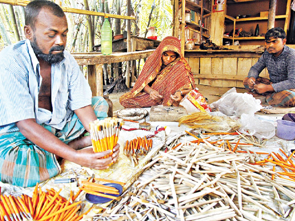 যশোরের কেশবপুরের আলতাপোল গ্রামে নিজের কারখানায় তুলি তৈরিতে ব্যস্ত নজরুল ইসলাম (বাঁয়ে), তাঁর স্ত্রী জামেলা বিবি ও ছেলে আলম হোসেন l ছবি: এহসান-উদ-দৌলা