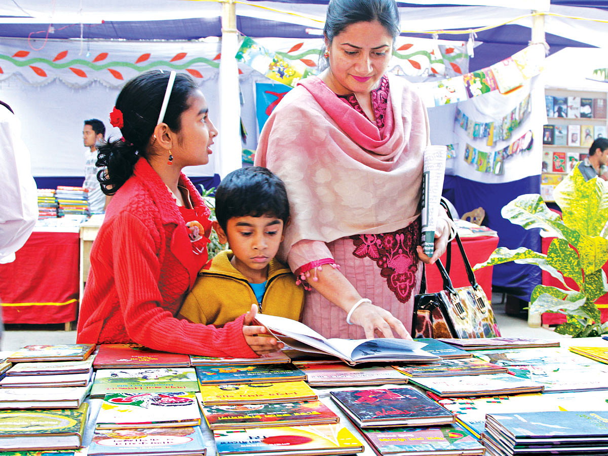 মুসলিম ইনস্টিটিউট প্রাঙ্গণে সিটি করপোরেশন আয়োজিত বইমেলায় বই দেখছেন পাঠকেরা l প্রথম আলো