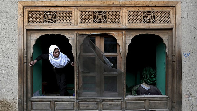 বোমা হামলায় ভেঙে যাওয়া জানালা দিয়ে বাইরের পরিস্থিতি বোঝার চেষ্টা করছে আফগান মেয়েটি। গতকাল বুধবার আফগানিস্তানের রাজধানী কাবুলে প্রেসিডেন্ট প্রাসাদের কাছে অবস্থিত এই দরগায় আত্মঘাতী বোমা হামলা হয়। এতে ছয় ব্যক্তি মারা যান। ছবি: রয়টার্স