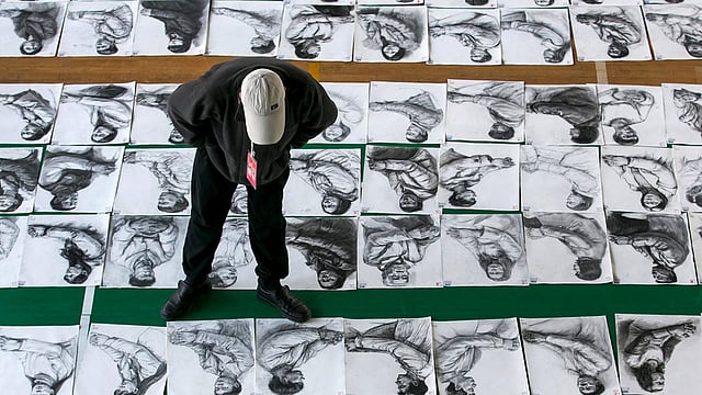 চীনের ঝেজিয়াং প্রদেশের হাংঝুর চায়না একাডেমিতে গতকাল বুধবার প্রবেশিকা পরীক্ষায় অংশ নেওয়া প্রার্থীদের আঁকা ছবি দেখছেন এক শিক্ষক। ছবি: রয়টার্স