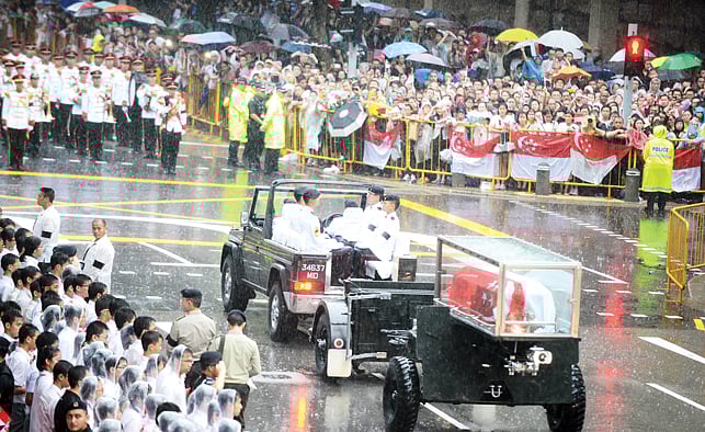 শেষকৃত্যের জন্য লি কুয়ান ইউর মরদেহ বৃষ্টির মধ্যে সামরিক শকটে করে পার্লামেন্ট ভবন থেকে নিয়ে যাওয়া হয় l এএফপি