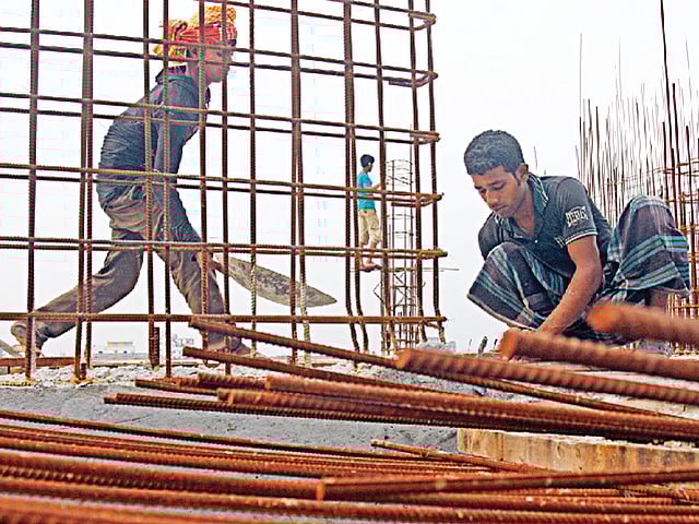রাজধানীর তেজগঁাও এলাকার একটি বহুতল ভবনের নির্মাণ কাজ করছেন শ্রমিকেরা l ছবি: হাসান রাজা