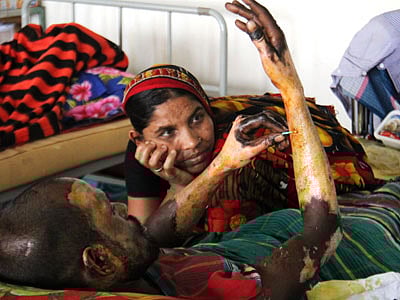 ট্রাকের  শ্রমিক ফারুক কটনবার্ড দিয়ে নিজের হাত পরিষ্কার করছেন। পাশে তাঁর স্ত্রী বসে আছেন। ছবি সাবিনা ইয়াসমিন