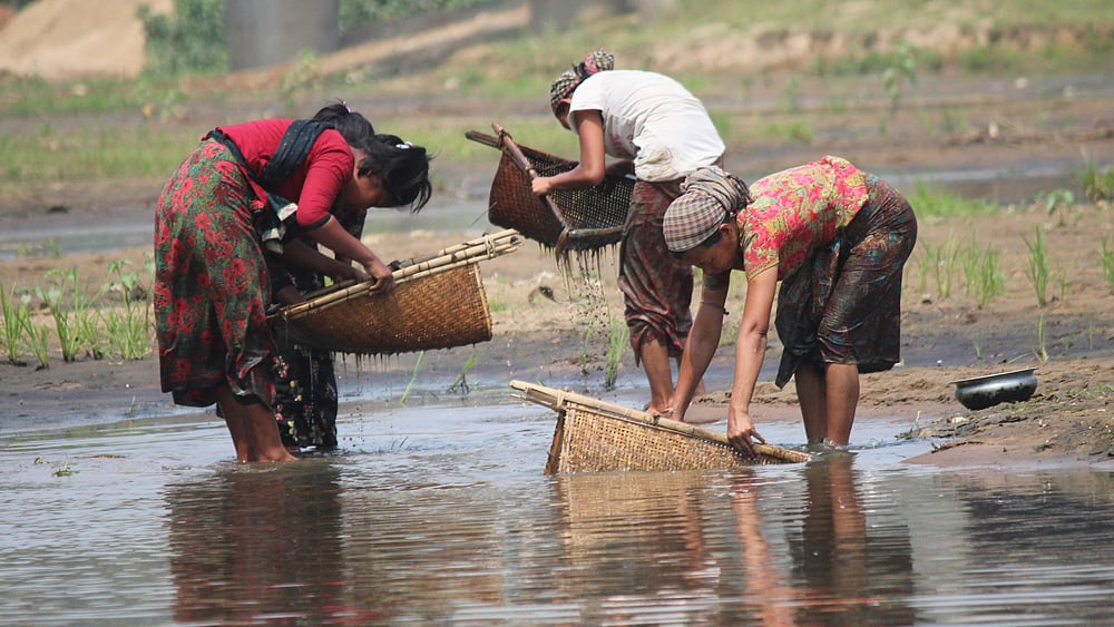 পাহাড়ি চেঙ্গী নদীতে বৈশাখের অল্প পানিতে মাছ ধরার রুইয়ের সাহায্যে ছোট মাছ, কাঁকড়া ও শামুক ধরতে ব্যস্ত মারমা তরুণীরা। ছবিটি সম্প্রতি খাগড়াছড়ি শহরের চেঙ্গী সেতু এলাকা থেকে তোলা। ছবি: নীরব চৌধুরী, খাগড়াছড়ি