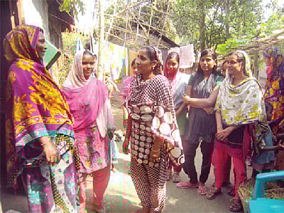 গ্রামের এক মাকে তাঁর মেয়ের বিয়ের বয়স হওয়ার তারিখ মনে করিয়ে দিচ্ছেন রুপালি বেগম (বাঁ থেকে তৃতীয়)। সঙ্গে কিশোরীরা l ছবি: প্রথম আলো