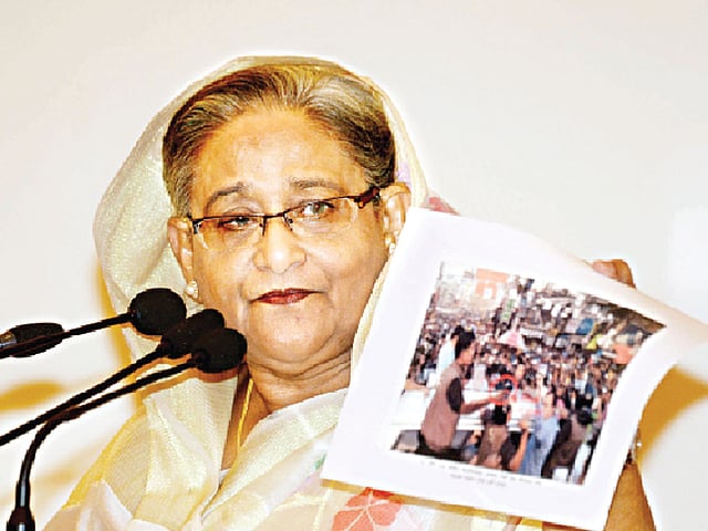 গতকাল সংবাদ সম্মেলনে সম্প্রতি খালেদা জিয়ার গাড়িবহরে হামলাকালে তাঁর ব্যক্তিগত নিরাপত্তা বাহিনীর কর্মকাণ্ডের ছবি দেখান প্রধানমন্ত্রী শেখ হাসিনা l বাসস