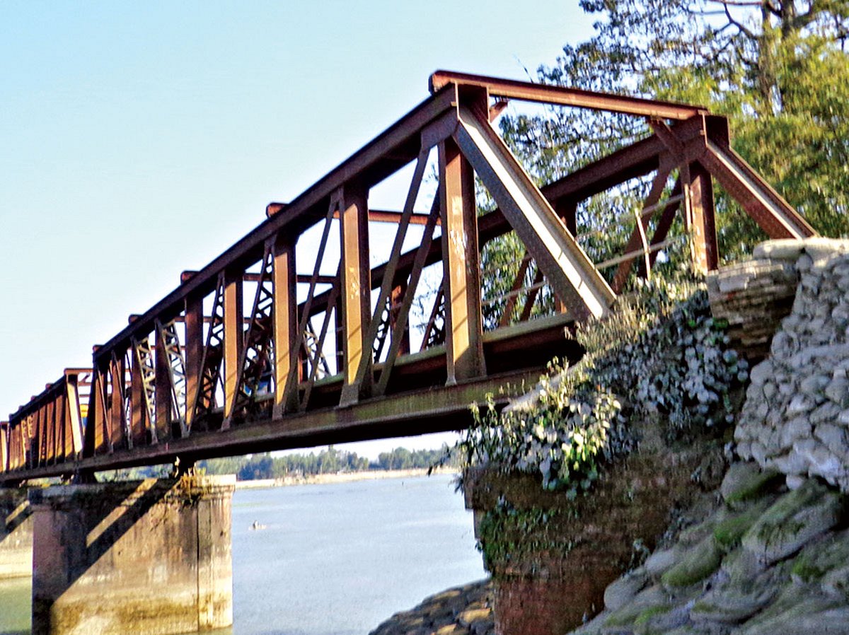 কুড়িগ্রামের ভূরুঙ্গামারী উপজেলার সোনাহাট সেতুর পূর্ব পাড়ের সংযোগ সড়কের মাটি ধসে পড়েছে। এ কারণে এর ওপর দিয়ে ঝুঁকি নিয়ে চলাচল করছে যানবাহন l ছবি: প্রথম আলো