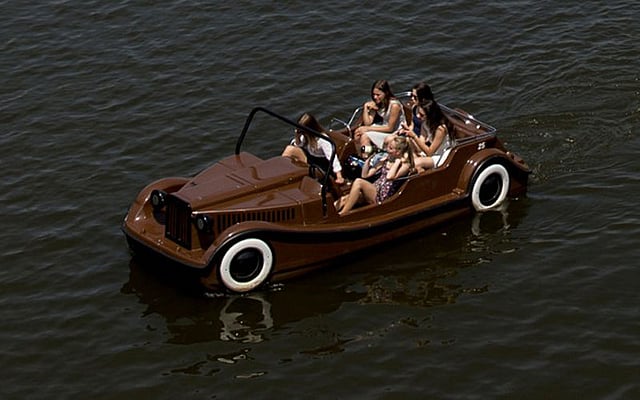 তীব্র গরম থেকে স্বস্তি পেতে প্রাগের একটি নদীতে নৌকা নিয়ে ঘুরছেন পর্যটকেরা। ছবিটি প্রাগের চার্লস ব্রিজের কাছ থেকে তোলা। ছবি: এএফপি