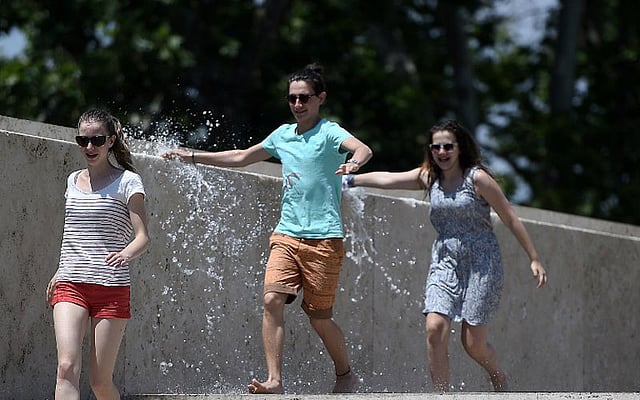 তীব্র গরম থেকে স্বস্তি পেতে পানি ছিটিয়ে আনন্দ করছেন তরুণ-তরুণীরা। ছবিটি ইতালির রোম শহর থেকে তোলা। ছবি: এএফপি