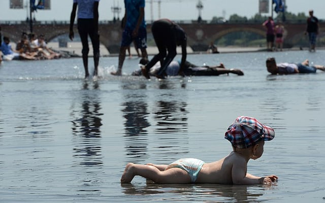 একটু স্বস্তির জন্য কৃত্রিম ঝরনার পাশে এভাবেই শুয়ে রাখা হয়েছে শিশুটিকে। ছবিটি ফ্রান্সের বোরডক্স থেকে তোলা। ছবি: এএফপি