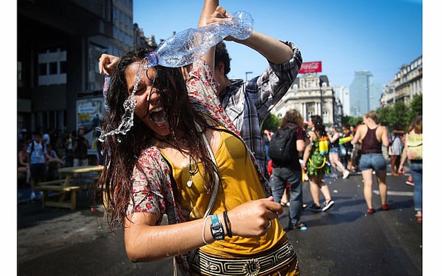 তীব্র গরমে পানি নিয়ে খেলছেন তরুণ-তরুণীরা। ছবিটি বেলজিয়ামের ব্রাসেলস থেকে তোলা। ছবি: এএফপি