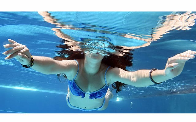 তীব্র গরম থেকে স্বস্তি পেতে সুইমিংপুলে সাঁতার কাটছেন এক তরুণী। ছবিটি জার্মানির কার্লসরুহ থেকে তোলা। ছবি: এএফপি