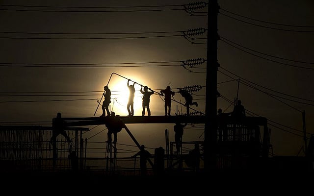 সন্ধ্যা প্রায় হয়ে আসছে। এমন আলো-আঁধারির মাঝে কাজ করছেন কয়েকজন শ্রমিক। ছবিটি ফিলিপাইনের রাজধানী ম্যানিলা থেকে তোলা। ছবি: এএফপি