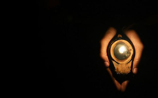 অন্ধকারে মঙ্গলপ্রদীপ। ছবিটি শ্রীলঙ্কার রাজধানী কলম্বো থেকে তোলা। ছবি: এএফপি