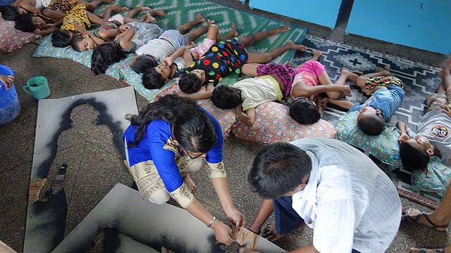 কলকাতার স্বেচ্ছাসেবকেরা দেয়ালে আঁকার জন্য ‘হারিয়ে যাওয়া’ মেয়েদের স্টেনসিল তৈরি করছেন। ছবি: দ্য গার্ডিয়ান।