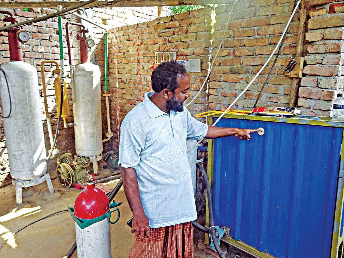 মিটার দেখাচ্ছেন আবদুস সালাম। যেখানে সংকুচিত বায়োগ্যাস উৎপাদনের পরিমাণ বোঝা যায় l ছবি: প্রথম আলো