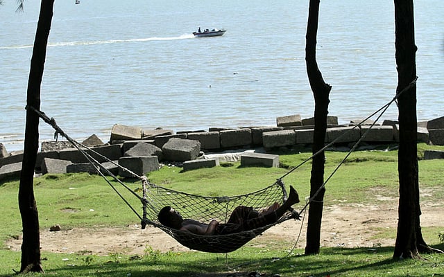 গাছের ছায়ায় দোলনায় বিশ্রাম নিচ্ছেন এক পর্যটক। ছবি: সৌরভ দাশ, চট্টগ্রাম