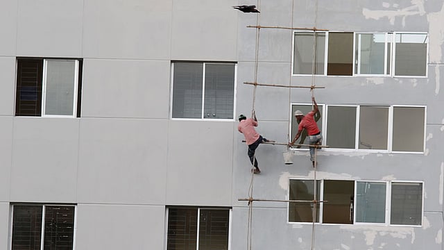 মাথায় নেই হেলমেট, নেই নিরাপত্তার পোশাক ৷ এগুলো ছাড়াই ঝুঁকি নিয়ে কাজ করছেন এ দুজন ৷ আজ শাহবাগ এলাকা থেকে তোলা ৷ ছবি: সাবিনা ইয়াসমিন