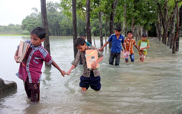 উজান থেকে নেমে আসা পাহাড়ি ঢল ও ভারী বর্ষণে সিলেটের গোয়াইনঘাট উপজেলার প্রায় ১৫টি গ্রাম ও বিভিন্ন সড়ক পানিতে তলিতে গেছে। ছবিতে পূর্ব দীঘিরপার সরকারি প্রাথমিক বিদ্যালয়ের শিক্ষার্থীরা পানি দিয়ে বাড়ি ফিরছে। ছবিটি আজ বৃহস্পতিবার দুপুরে তোলা। ছবি: আনিস মাহমুদ, সিলেট