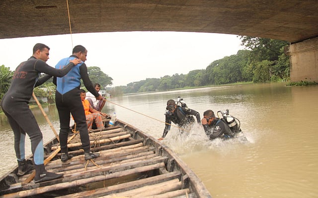 গতকাল বুধবার সন্ধ্যায় ফরিদপুর শহরের আলীপুর বিসর্জন ঘাটে কুমার নদে মনসা দেবী বিসর্জনের সময় সেতু থেকে লাফিয়ে পড়ে একজন নিখোঁজ হয়। বৃহস্পতিবার উদ্ধার অভিযানে ফরিদপুর ও খুলনার ফায়ার সার্ভিসের ডুবুরিরা কাজ করেন। ছবি: আলীমুজ্জামান, ফরিদপুর