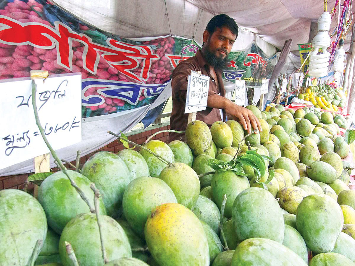 বাগানে আম নেই, কিন্তু রাজধানীর অনেক স্থানে এখনো চলছে আমের মেলা। আশ্বিনা জাতের আম বিভিন্ন নামে বিক্রি হচ্ছে এসব দোকানে। ছবিটি মঙ্গলবার ধানমন্ডি এলাকা থেকে তোলা l প্রথম আলো