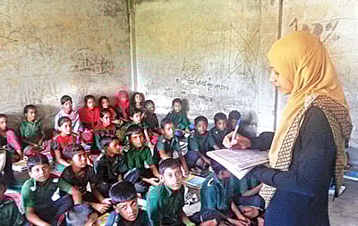 নেই টুল–বেঞ্চ ও আসবাব। মেঝেতে বসেই পড়ছে মহেশখালীর ঘটিভাঙা সরকারি প্রাথমিক বিদ্যালয়ের শিক্ষার্থীরা lপ্রথম আলো