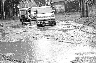 বগুড়া শহরের নামাজগড়-বারপুর সড়কের পিচের ঢালাই উঠে ছোট-বড় গর্ত হয়েছে। সামান্য বৃষ্টিতেই সেখানে পানি জমে যায়। ছবিটি গত ২১ সেপ্টেম্বর সড়কের ধরমপুর থেকে তোলা l প্রথম আলো