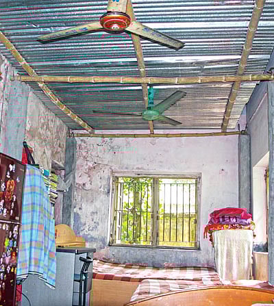 কলেজ ক্যাম্পাসে গ্রন্থাগারিকের ঘরের দৃশ্য এটি। পাকা বাড়িটির ছাদের নিচে পলেস্তারা খসে পড়া ও পানি পড়া ঠেকাতে টিনের চাল দেওয়া হয়েছে l ছবি: প্রথম আলো