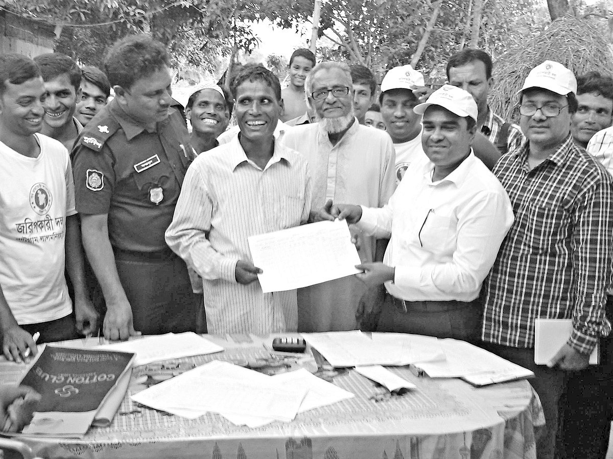 সদ্য বিলুপ্ত ১৩২ নম্বর বাঁশকাটা ছিটমহরি বাসিন্দাদের হাতে গতকাল ভূমি মালিকানার খতিয়ান হস্তান্তর করেন উপজেলা সহকারী কমিশনার (ভূমি) টি এম এ মোমিন l ছবি: প্রথম আলো