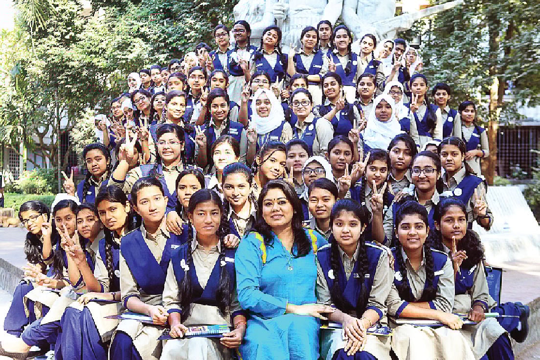 ঢাকা বিশ্ববিদ্যালয়ে অপরাজেয় বাংলার পাদদেশে স্বর্ণ কিশোরী নেটওয়ার্ক ফাউন্ডেশনের সভাপতি ফারজানা ব্রাউনিয়ার সঙ্গে কিশোরীরা। ছবি: অধুনা